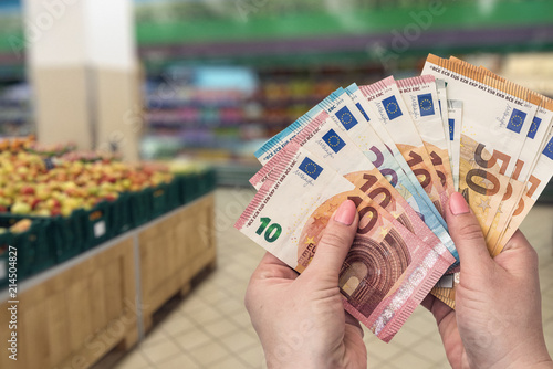 Shopping in fruit store, female hands with euro, closeup