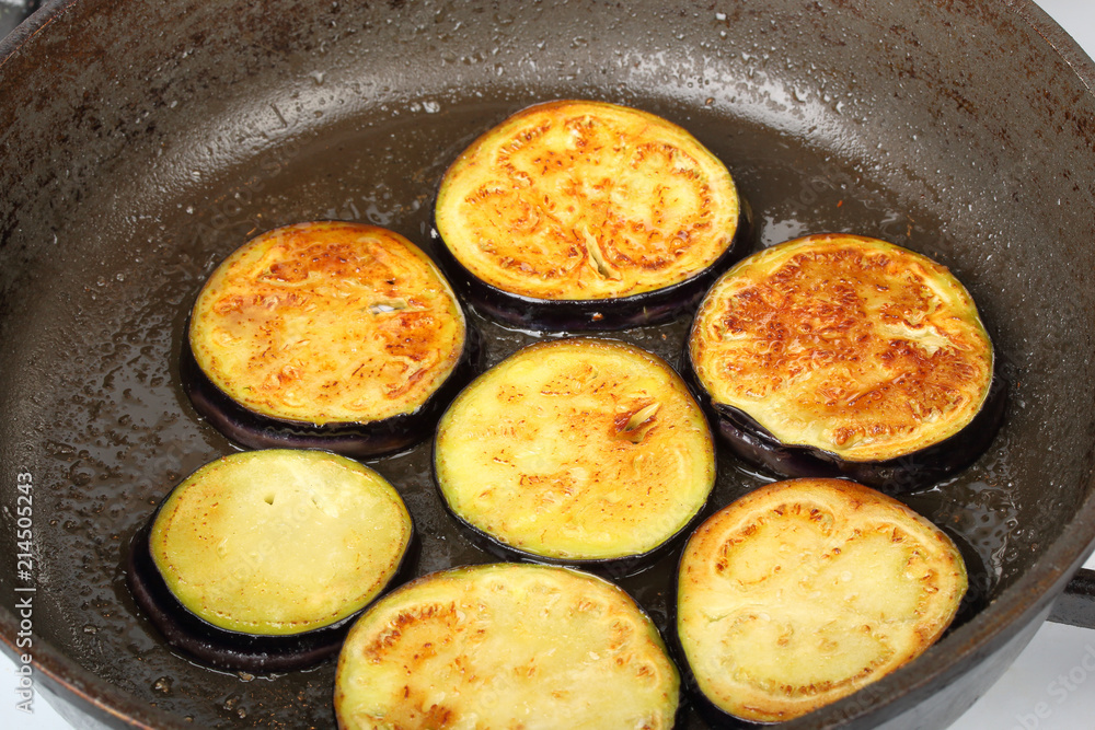 Sliced eggplants fry in a pot with oil Sliced eggplants fry in a pot with oil