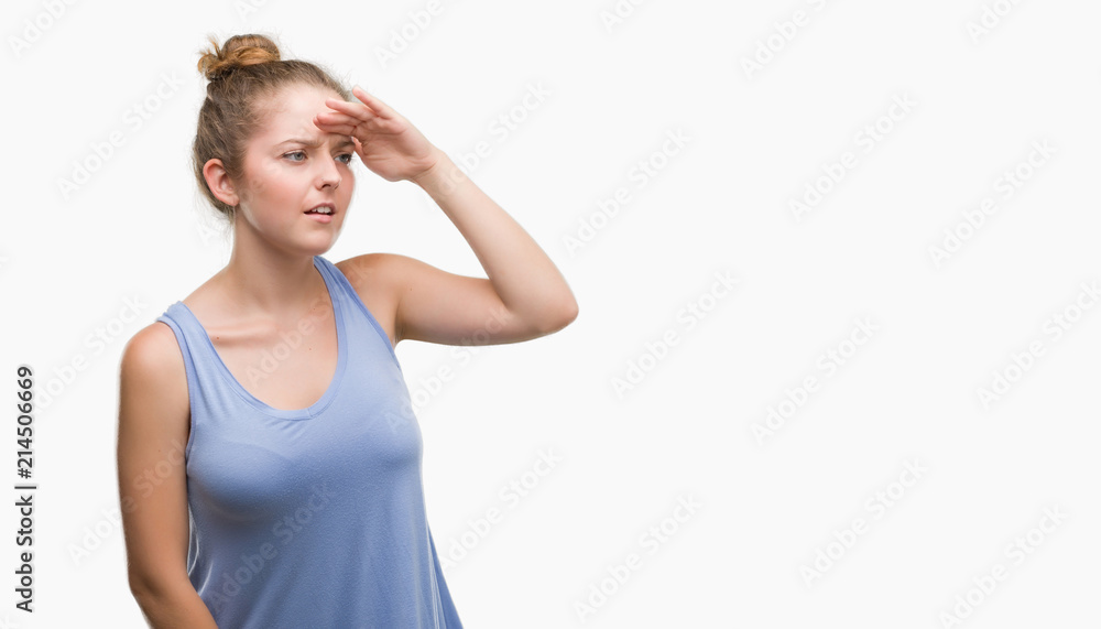 Young blonde woman very happy and smiling looking far away with hand over head. Searching concept. Young blonde woman very happy and smiling looking far away with hand over head. Searching concept.