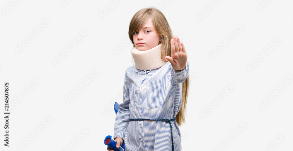 Young blonde child injured wearing neck collar and crutches with open hand doing stop sign with serious and confident expression, defense gesture Young blonde child injured wearing neck collar and crutches with open hand doing stop sign with serious and confident expression, defense gesture