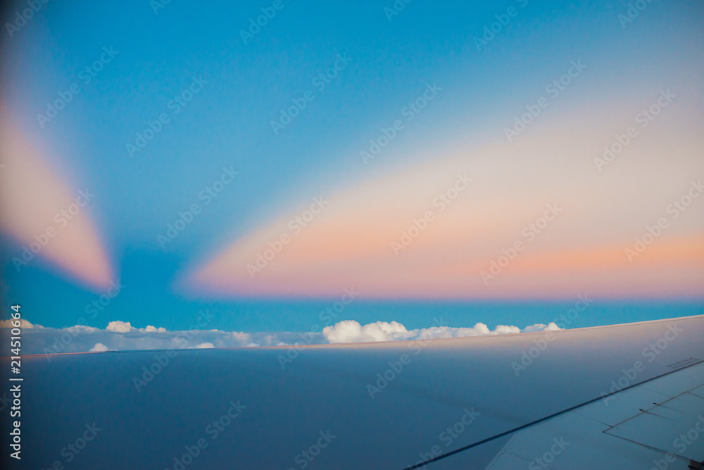 Beautiful sunset above clouds from airplane perspective. High resolution image with sun rays