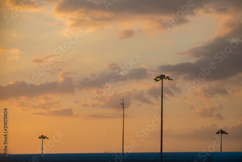 View of the airport air traffic control tower against the beautiful blue orange sky at sunset