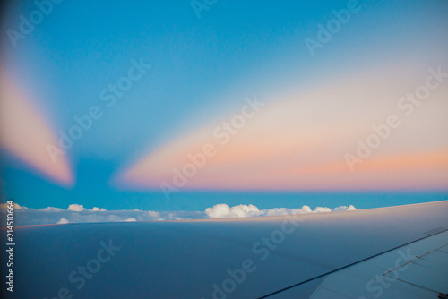 Beautiful sunset above clouds from airplane perspective. High resolution image with sun rays