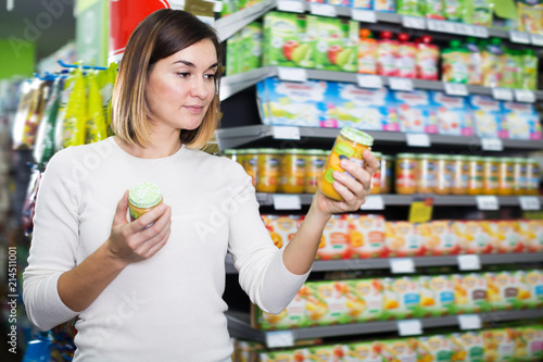 Happy female shopper searching for baby food