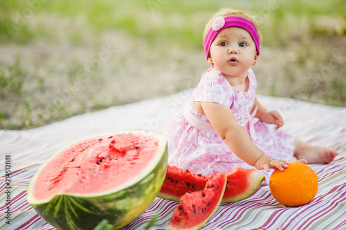 Fényképezés Baby girl on picnic. eating watermelon outdoors. Childhood.