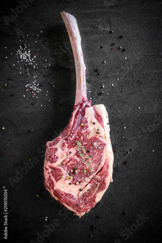 Raw tomahawk stake bone on the dark background,selective focus photo