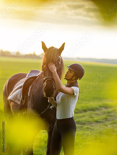 Young Woman with her horse at sunrise.