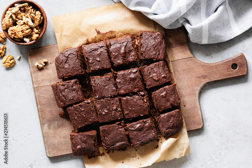 Chocolate brownie squares with walnuts on cutting board, top view, horizontal composition. Flat lay food photo