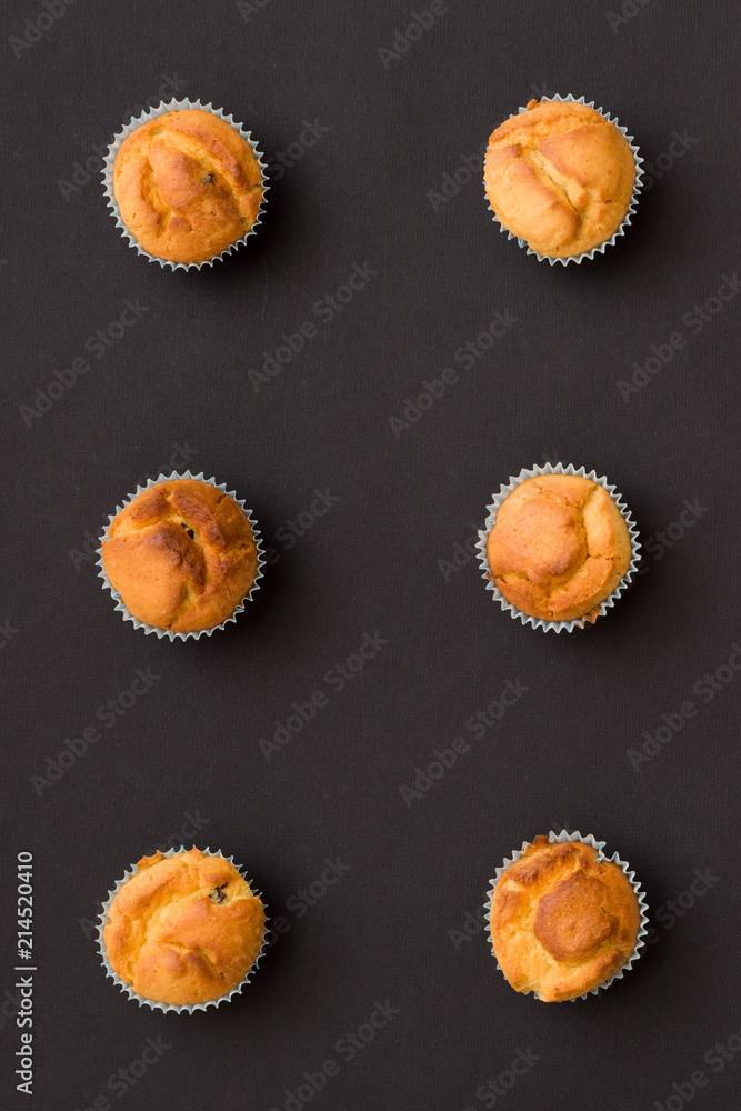 Closeup of homemade vanilla muffins places in rows on black background. Healthy snack. Closeup of homemade vanilla muffins places in rows on black background. Healthy snack.