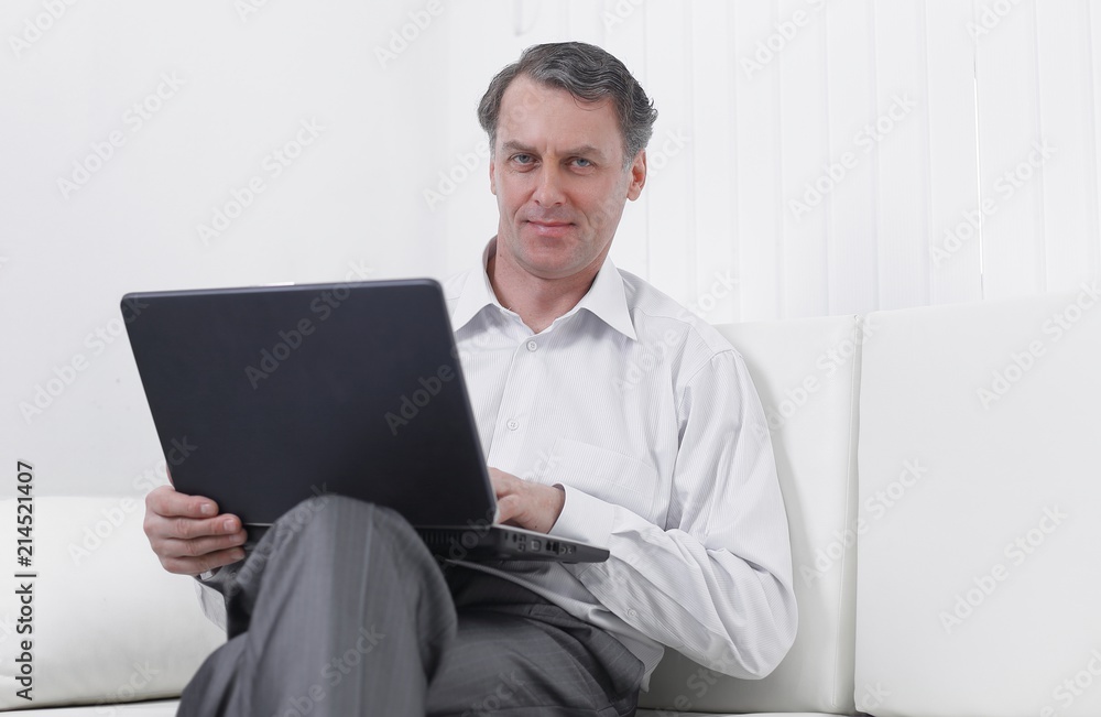successful business man working on laptop sitting on sofa successful business man working on laptop sitting on sofa