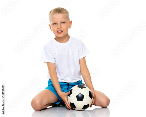 Little boy is playing with a soccer ball.