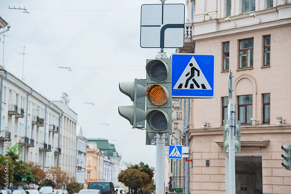 Road sign of a pedestrian crossing and traffic light with yellow light ...