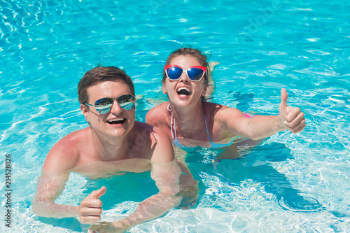 young couple relaxing and having fun by the luxury pool