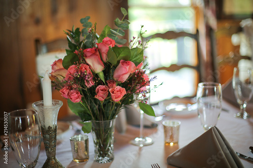 Wedding Reception Table Decorated with Silver and a Pink  White  and Green Centerpiece of Roses