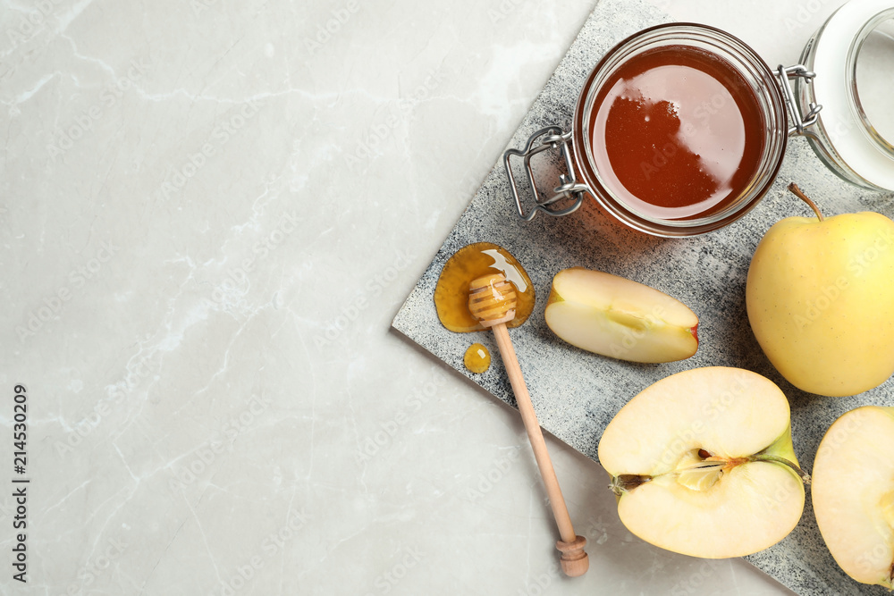 Flat lay composition with jar of honey, apples and dipper on marble background Flat lay composition with jar of honey, apples and dipper on marble background