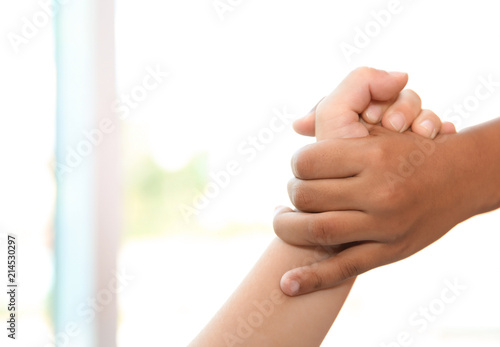 Children holding hands on blurred background, closeup. Unity concept