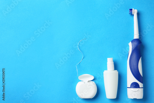 Flat lay composition with electric toothbrush and oral hygiene products on color background