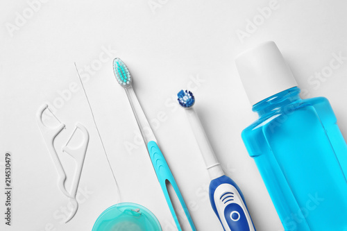Flat lay composition with toothbrushes and oral hygiene products on white background photo