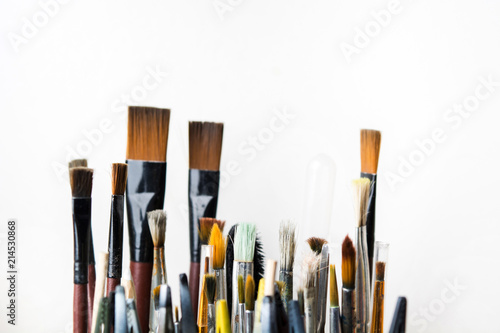 Various colorful used brushes for art on white background