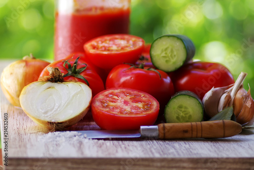 tomatoes and glass bottle of tomato paste on table