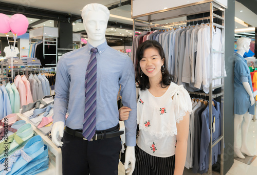 Shopping and couple concept : Smile Asian woman in casual fashion, walk arm in arm together with a mannequin in shirt with necktie.
