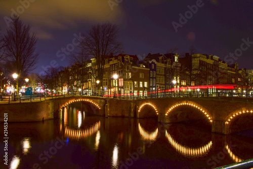 Canal junction in Amsterdam, Netherlands at night.