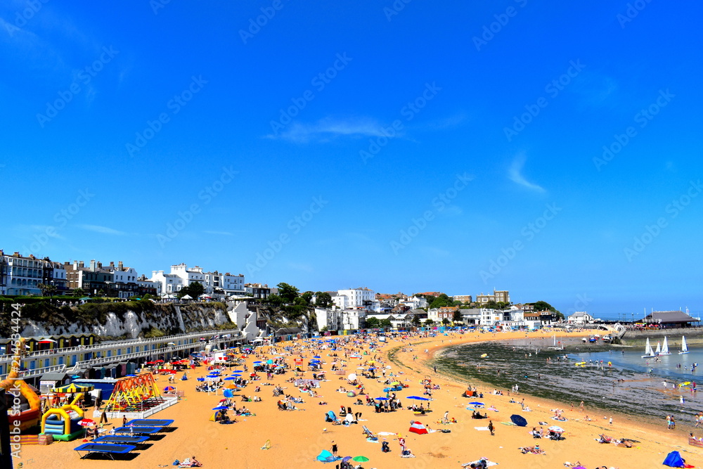 Tourists and locals flock to the beach in Broadstairs escaping the heatwave.Water sports for adults and kids,swings,bouncy castle keep all family members entertained whilst on the beach.Kent,UK
