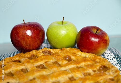 Closeup, Three apples next to freshly made apple pie 
