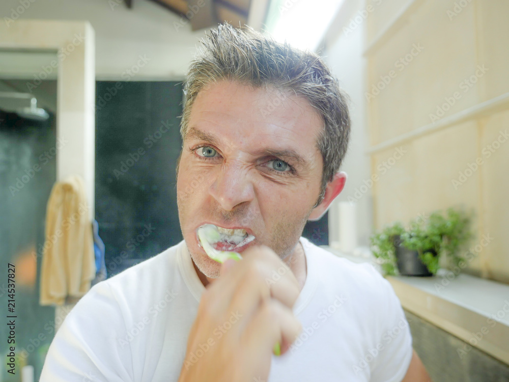 © TheVisualsYouNeed - oung attractive white man with blue eyes at home bathroom brushing tooth with toothbrush energically looking at himself on toilet mirror © TheVisualsYouNeed - oung attractive white man with blue eyes at home bathroom brushing tooth with toothbrush energically looking at himself on toilet mirror