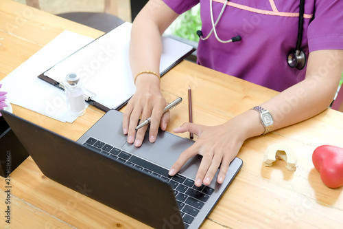 Female Doctor hand typing on keyboard laptop in office.