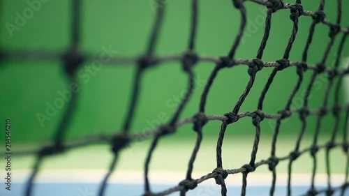 Close up of tennis equipment on the court. Sport, recreation concept. Yellow tennis balls hit the net on a clay green blue court next to the white line with copy space and soft focus photo