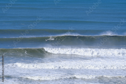 Surfer dwarfed by massive waves on the Gold Coast after a storm