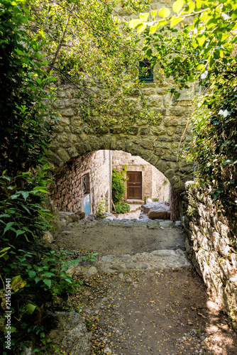 View through a stone archway and cobblestone staircase in the old French village of Labeaume in southern France