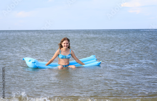girl of thirteen with an inflatable mattress