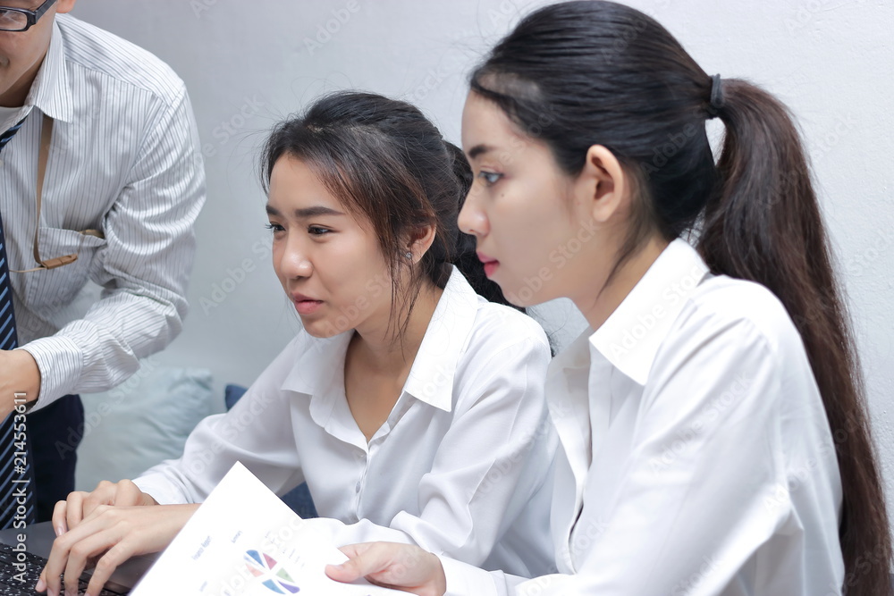 Asian business people with laptop working together in modern office. Selective focus and shallow depth of field. Asian business people with laptop working together in modern office. Selective focus and shallow depth of field.