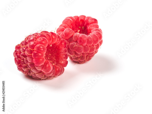 Close up view of two ripe red raspberry berries on white background. Organic raspberries with copy space for text, isolated on white with clipping path. Vegan food concept