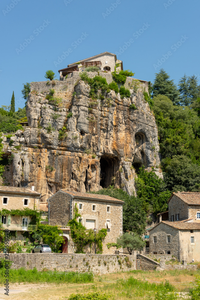 View of rocks with cave entrance at the medieval village Labeaume at the river Ardeche in France