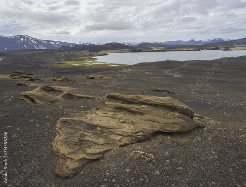 view on landscape with Colorful crater lake and volcanic snow covered mountains and dirty road in Veidivotn lakes, popular fishing area for local, central Iceland highlands in black lava desert photo