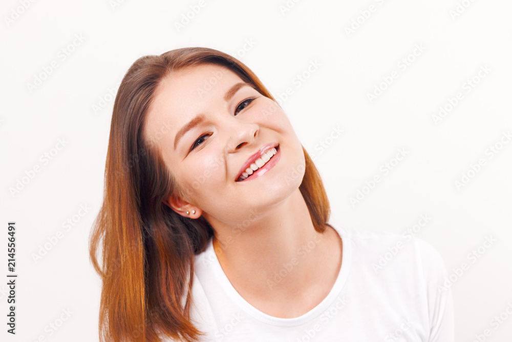 Beautiful happy girl teenager in t-shirt smiles in white studio Beautiful happy girl teenager in t-shirt smiles in white studio