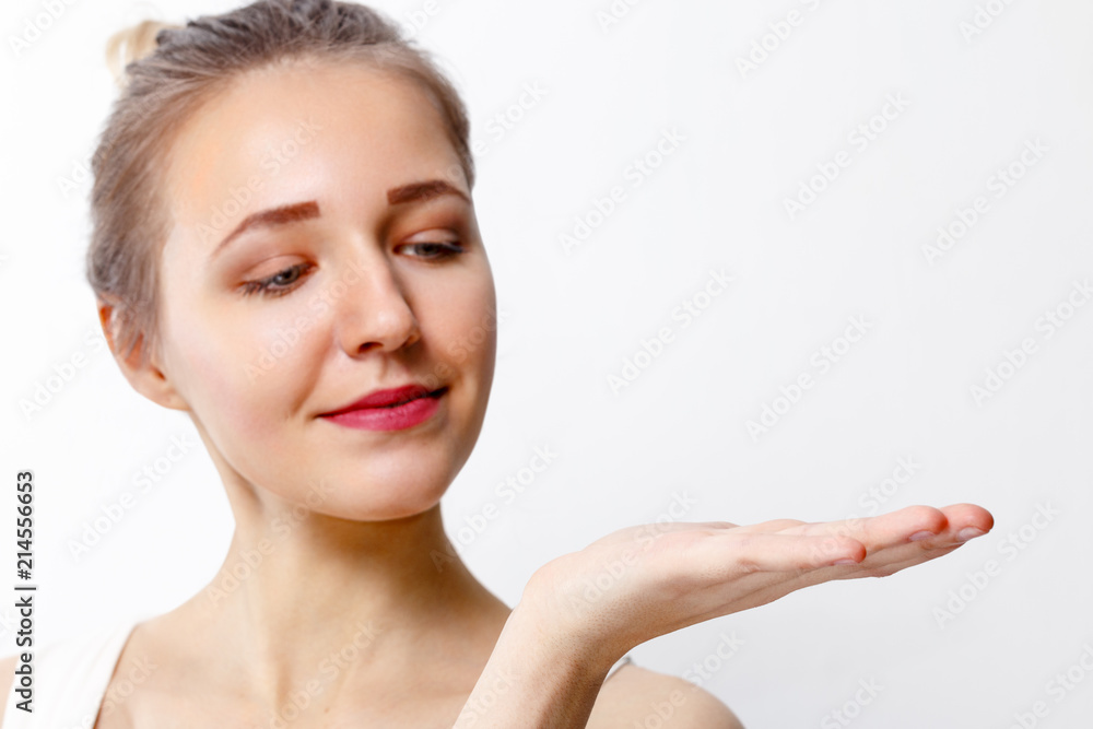 Pretty young girl with make-up shows palm in studio, close up portrait, focus on palm Pretty young girl with make-up shows palm in studio, close up portrait, focus on palm