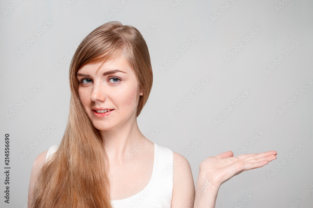 Beautiful young woman with make-up shows palm in studio Beautiful young woman with make-up shows palm in studio