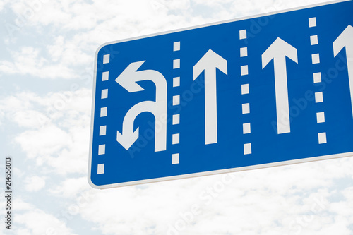 Blue Road Sign with white lines showing direction