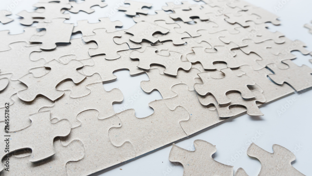Hand put missing jigsaw puzzle into the paper board Hand put missing jigsaw puzzle into the paper board