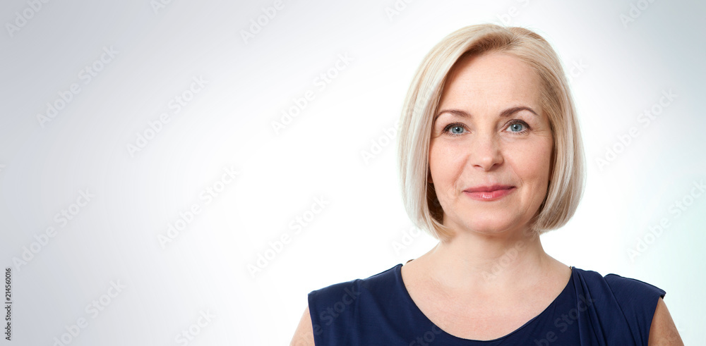 Fototapeta premium Attractive middle aged woman with beautiful smile on grey background