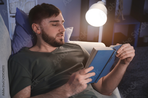 Young man reading book in e...