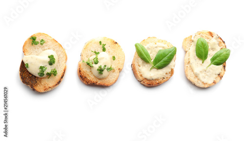 Toasted bread with cream cheese and herbs on white background