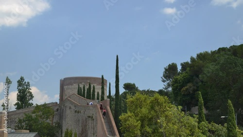 Time lapse of unidentifiable tourists climbing stairs on the medieval fortress wall, known in Catalan as Passeig de la Murala in Girona, Catalonia, Spain. photo