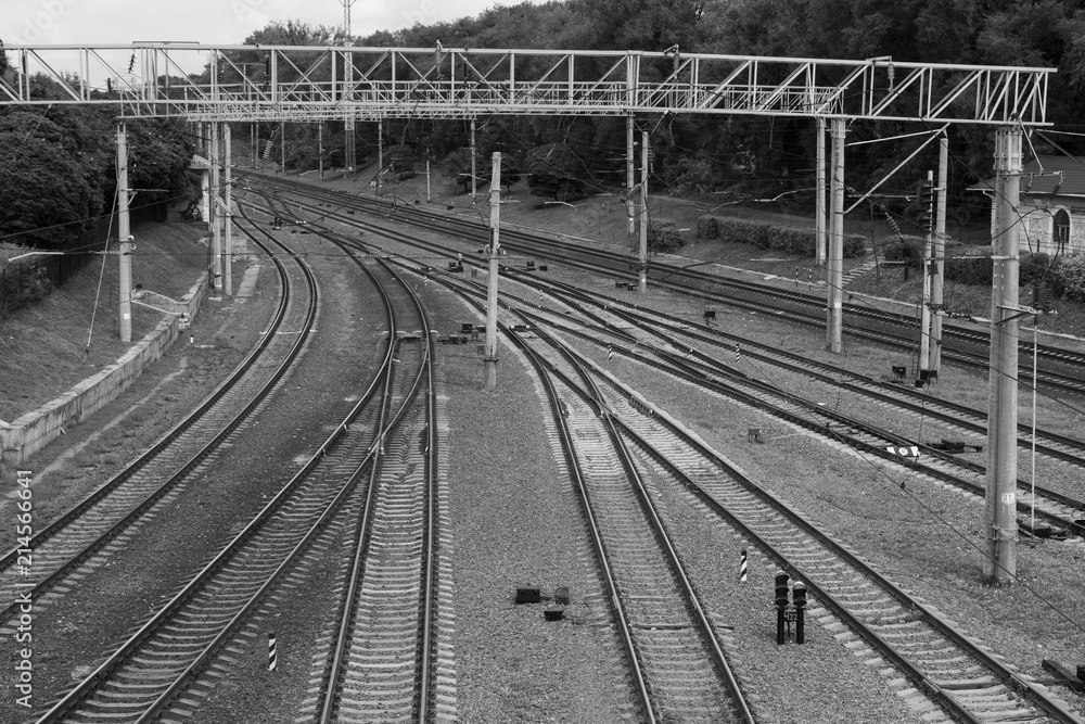 Railway branching. Sort Facility. Railroad tracks and entrances. A lot of rails. Crossing the rail. Weaving the rail in front of the train station. Railway junction. Black and white photo.