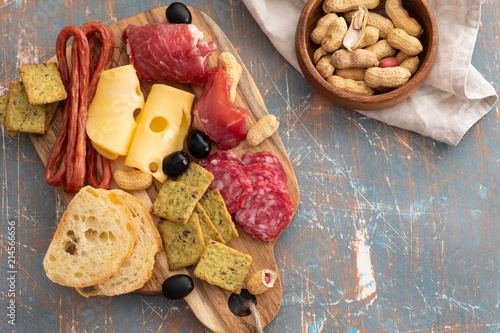 Platter with Spanish ham jamon or Italian prosciutto crudo, sliced Italian hard cheese. homemade dried meat salami, on old wooden board photo