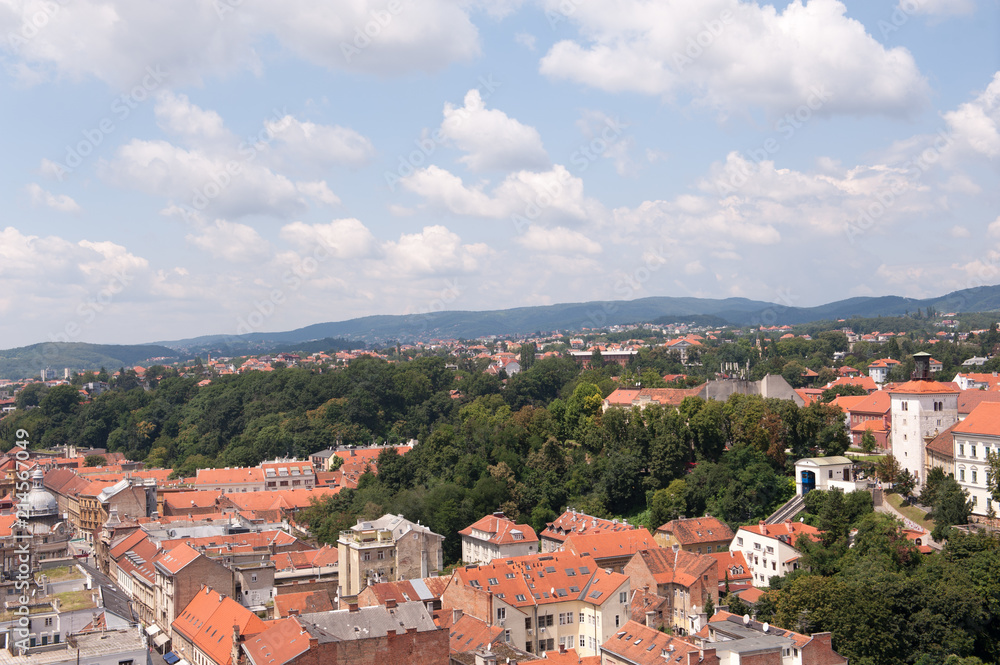 View of Zagreb and tower Lotrscak and part of Upper town, Croatia. Old orange roofs. Old city in Europe. Panoramic view of Zagreb with blue sky and white clouds.